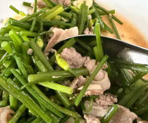 豚バラ肉と豚ひき肉を使った花ニラの炒め物の様子