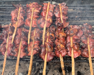 焼き竹で挟んで焼いているタップガイヤーンの様子